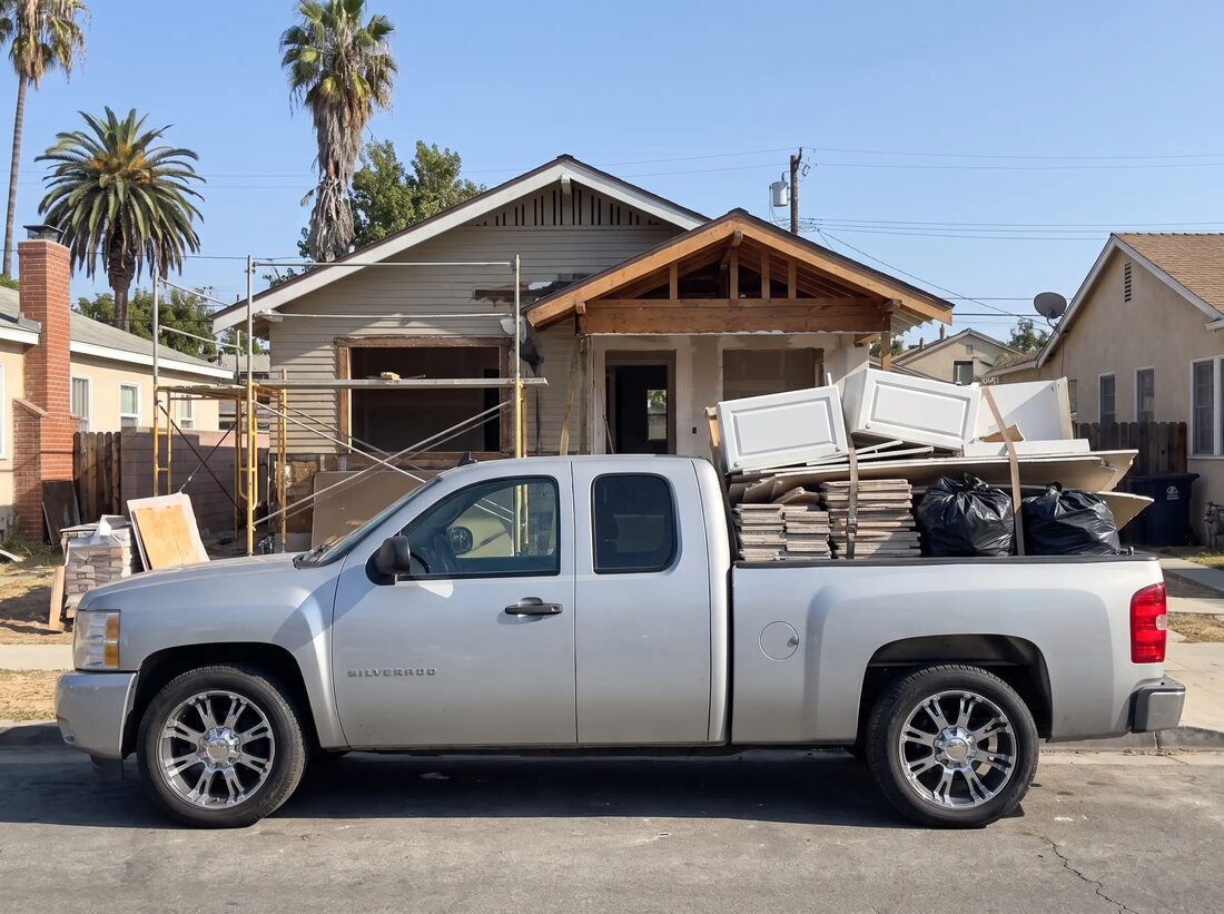 Truck bed loaded with cabinet doors, tile and contractor bags from an interior tear-out